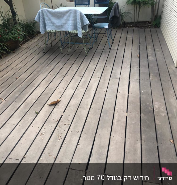 רצפת עץ בגינה עם שולחן וכיסאות מתכת